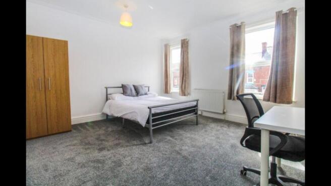 Bright and airy master bedroom featuring a comf...