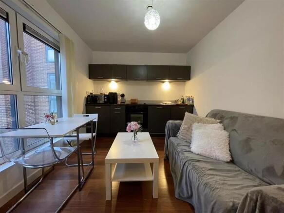 A cozy living space featuring a compact kitchen...