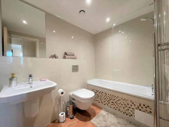 Bright and modern bathroom suite featuring a cl...