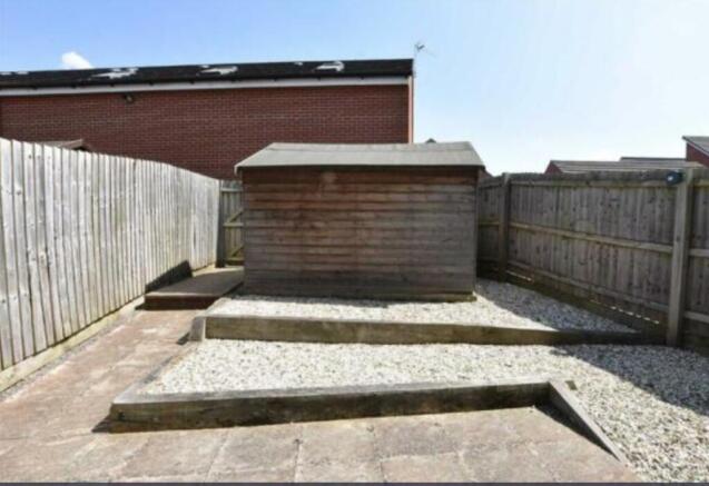 A well-maintained garden area featuring a woode...