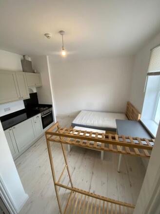 Compact and clean room featuring a small kitche...