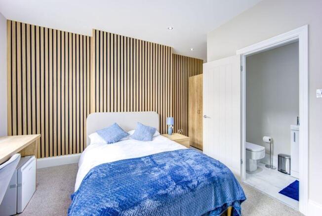 A modern and stylish master bedroom featuring a...