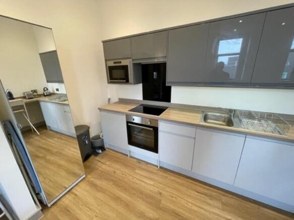 Modern kitchen with sleek grey cabinets, built-...
