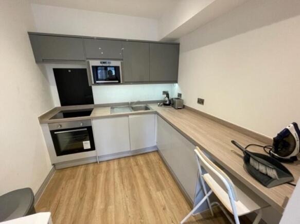 A modern, compact kitchen featuring sleek cabin...