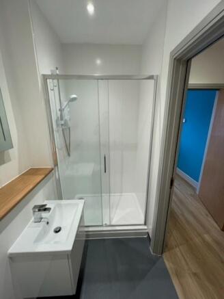 A modern bathroom featuring a clean glass-enclo...