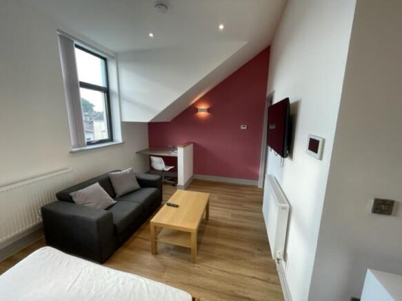 A modern master bedroom featuring a comfortable...