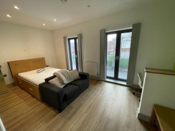 Bright and spacious master bedroom featuring la...