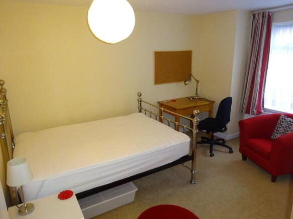 A tidy double bedroom featuring a metal-framed ...