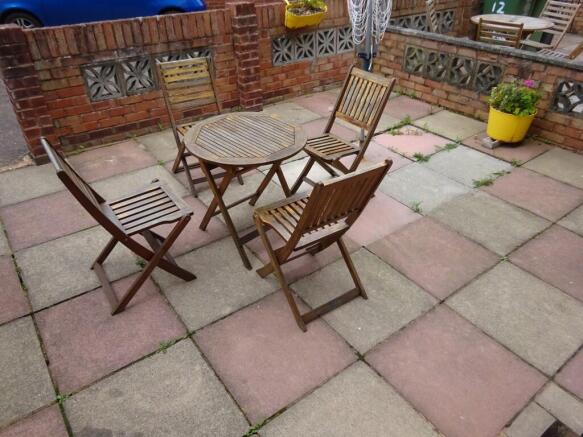 A cozy outdoor garden patio with a wooden table...