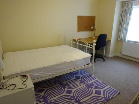 A bright double bedroom featuring a comfortable...