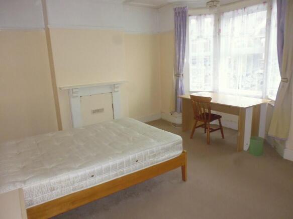 Bright and spacious bedroom featuring a large w...