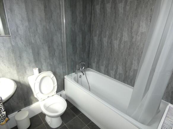 Modern bathroom featuring a clean white bathtub...