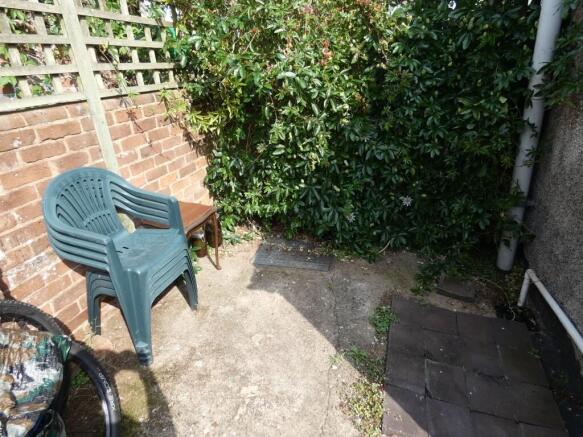 A small, sunny outdoor garden area featuring a ...