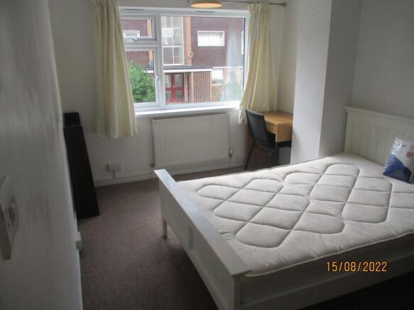 A bright single bedroom featuring a clean white...