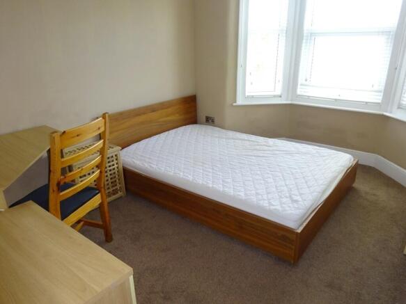A bright double bedroom featuring a comfortable...