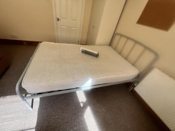 A tidy double bedroom featuring a metal frame b...