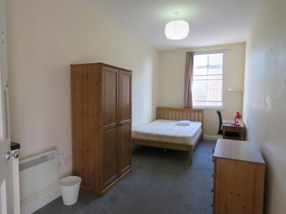 A tidy double bedroom featuring a wooden double...
