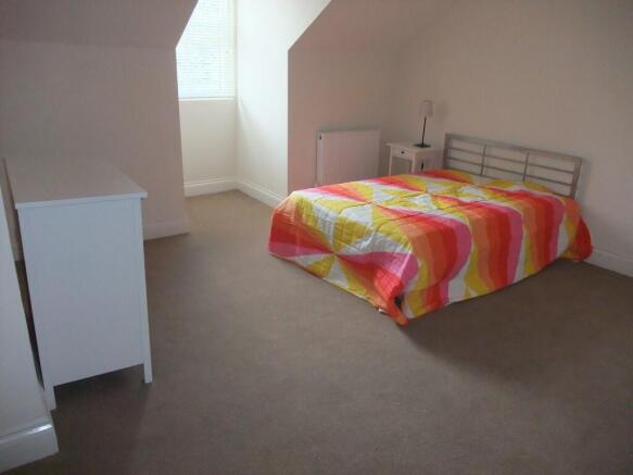 Bright and tidy double bedroom featuring a colo...