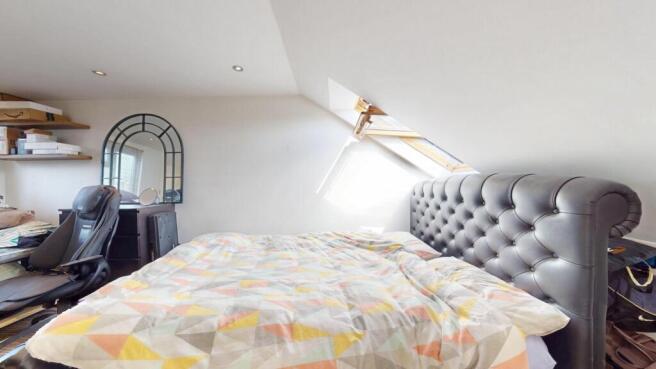 A spacious and cozy attic bedroom with a large ...