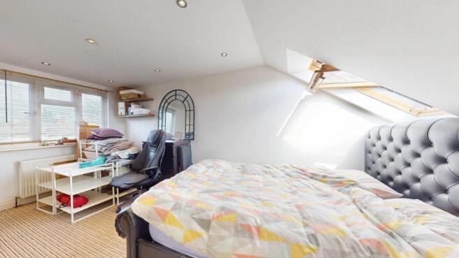 Bright and cozy attic bedroom featuring a comfo...
