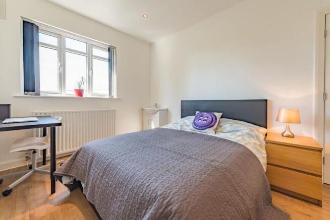 A bright and tidy double bedroom featuring a co...
