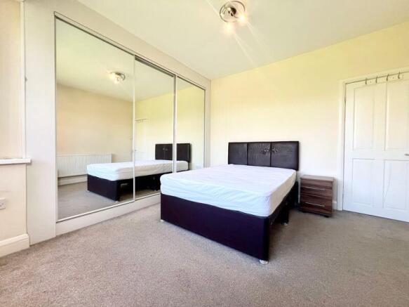 A bright and tidy double bedroom featuring a co...