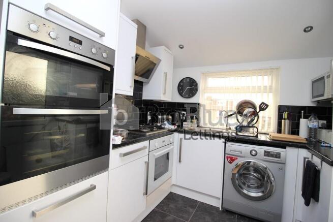 Bright and modern kitchen featuring built-in do...