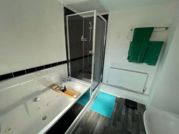 Bright and clean bathroom suite featuring a lar...