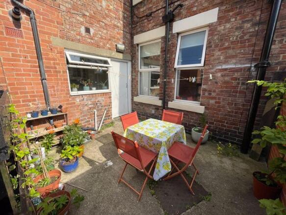 A charming and cozy outdoor garden area with a ...