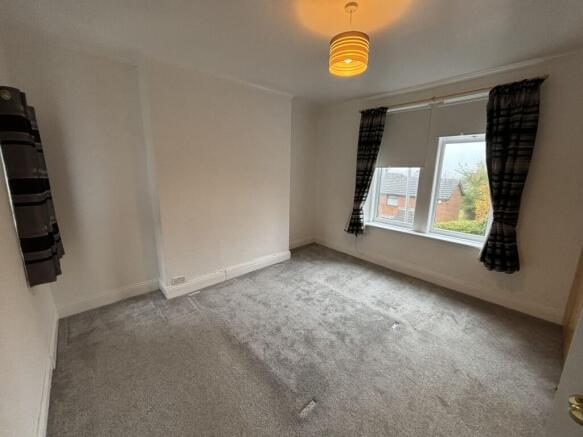 A bright double bedroom featuring neutral walls...