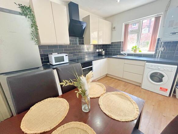Bright and modern kitchen featuring cream cabin...