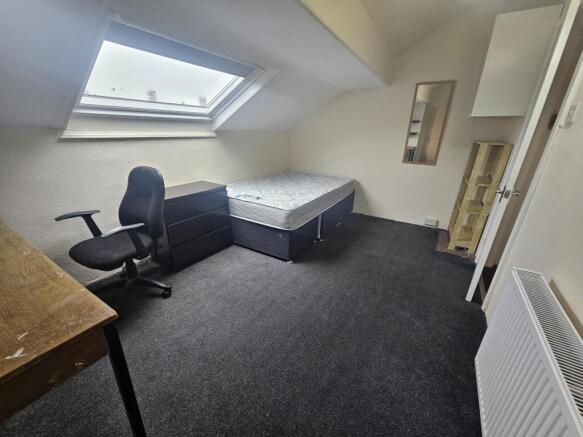 A bright and tidy living room with a large wind...