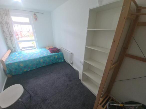 A cozy single bedroom featuring a comfortable b...