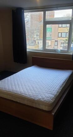 A spacious double bedroom with ample natural li...