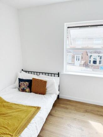 Bright, freshly decorated bedroom with a comfor...