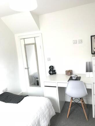 This inviting double bedroom features a cozy be...