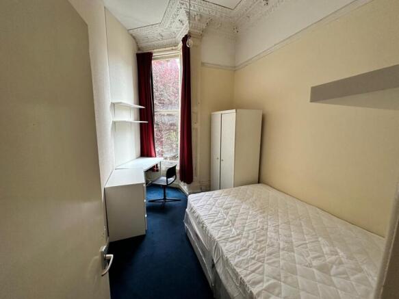 A spacious and well-lit double bedroom, perfect...