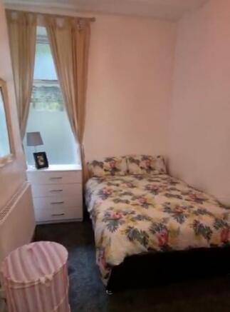 Cozy double bedroom featuring a colorful floral...