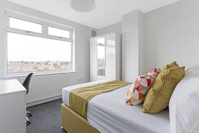 A bright and tidy double bedroom featuring a la...