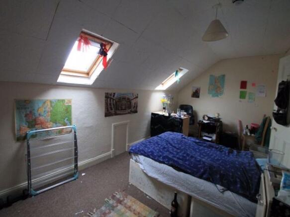 A cozy attic master bedroom featuring angled sk...