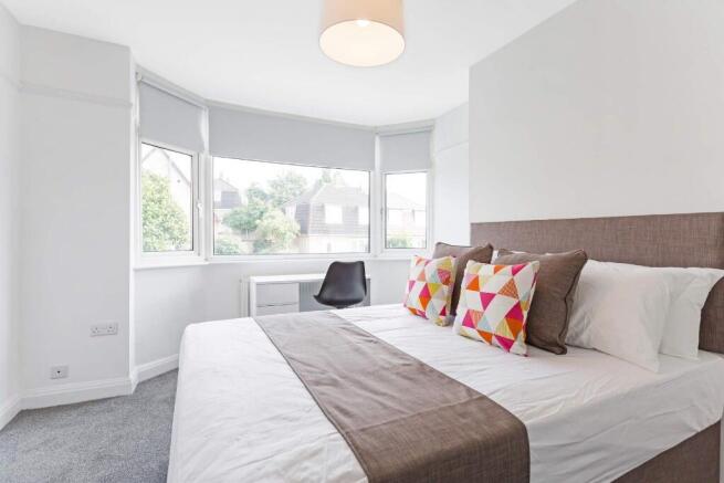 Bright and airy master bedroom featuring a larg...