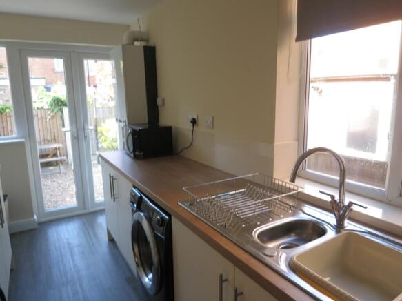 Bright and tidy kitchen featuring modern applia...