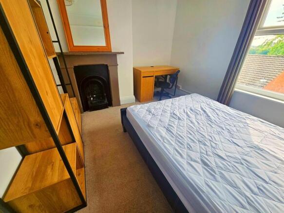 A bright and tidy bedroom featuring a comfortab...