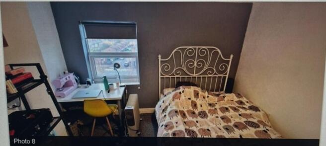 A cozy double bedroom featuring a stylish desk ...