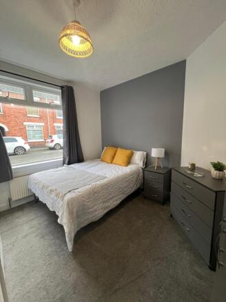 A cozy double bedroom featuring a comfortable b...