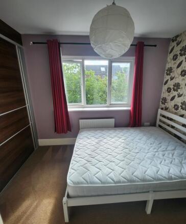 Bright double bedroom featuring a comfortable b...