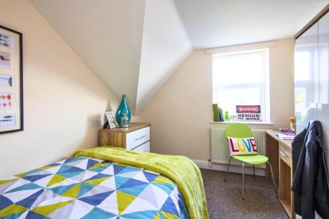 Bright and cozy single bedroom with a colorful ...