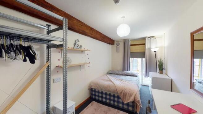A charming and tidy double bedroom featuring am...