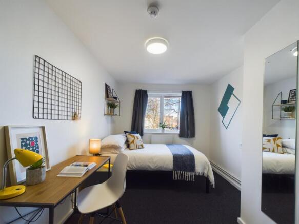 A bright and inviting double bedroom with moder...
