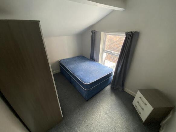 This cozy double bedroom features ample natural...